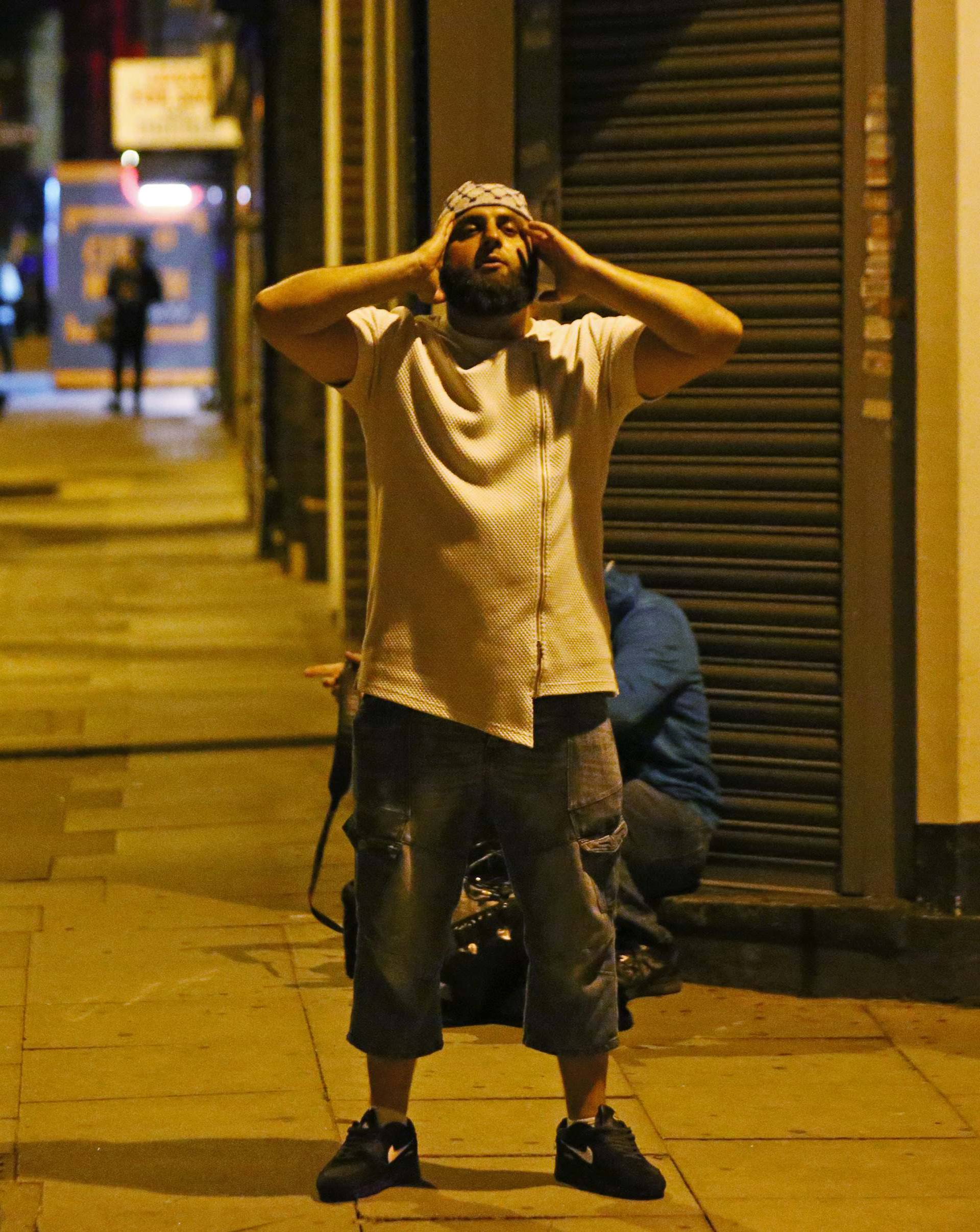 A man prays after a vehicle collided with pedestrians near a mosque in the Finsbury Park neighborhood of North London