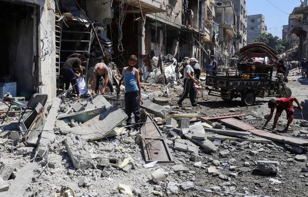 Palestinians inspect the site of an evacuated house, after it was hit by an Israeli air strike, at al-Shati (Beach) refugee camp, in Gaza City