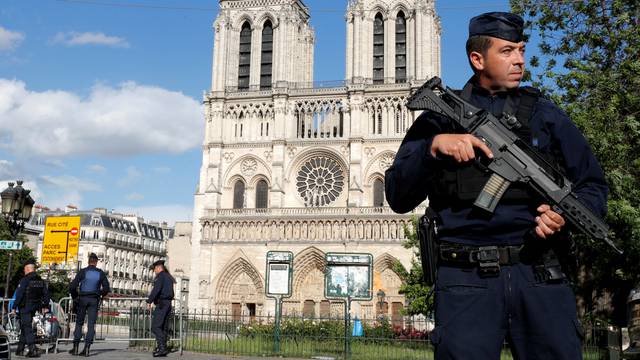 French police and gendarmes stand at the scene of a shooting incident near the Notre Dame Cathedral in Paris