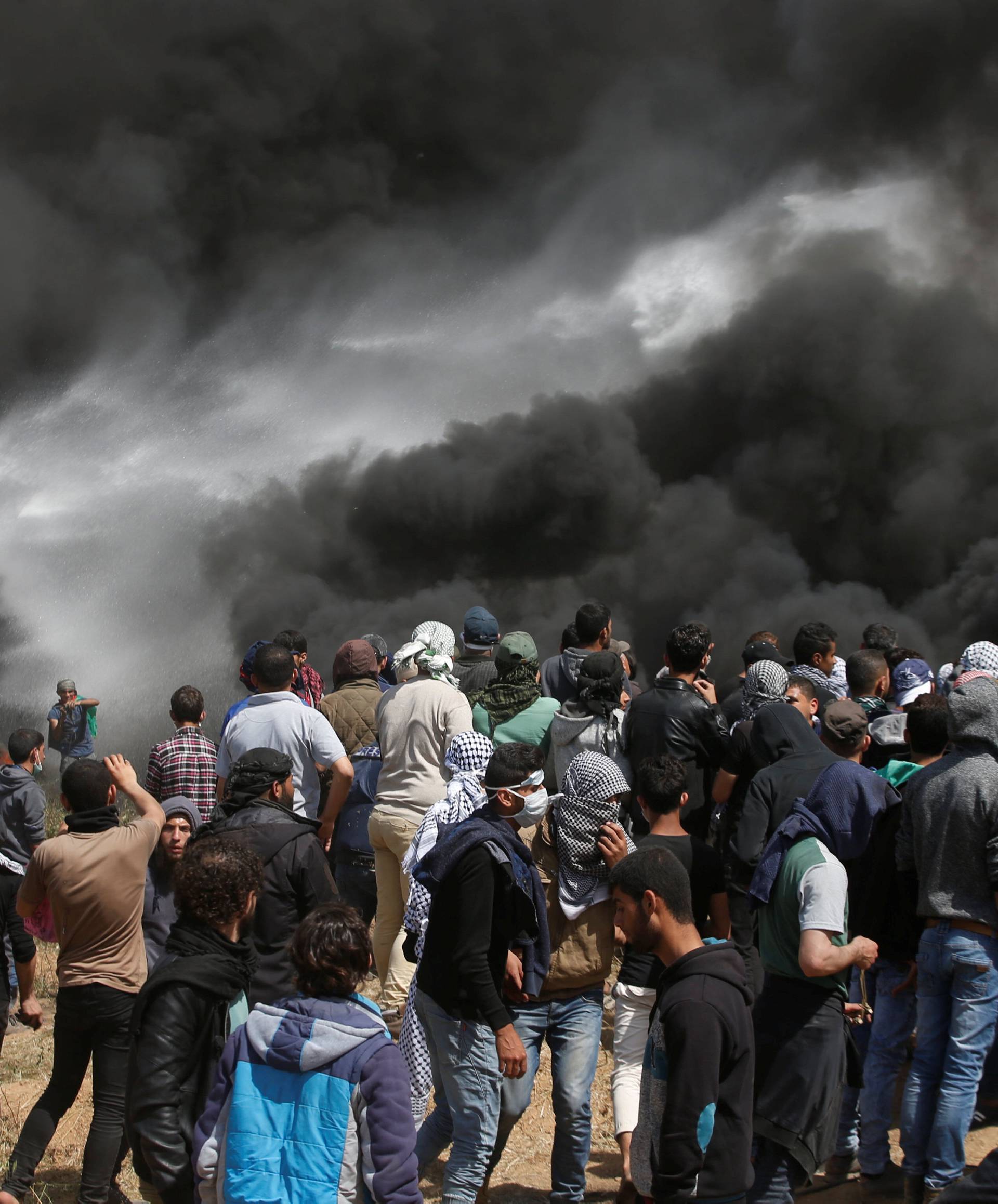 Palestinian demonstrators gather at the Israel-Gaza border during clashes with Israeli troops at a protest demanding the right to return to their homeland, east of Gaza City
