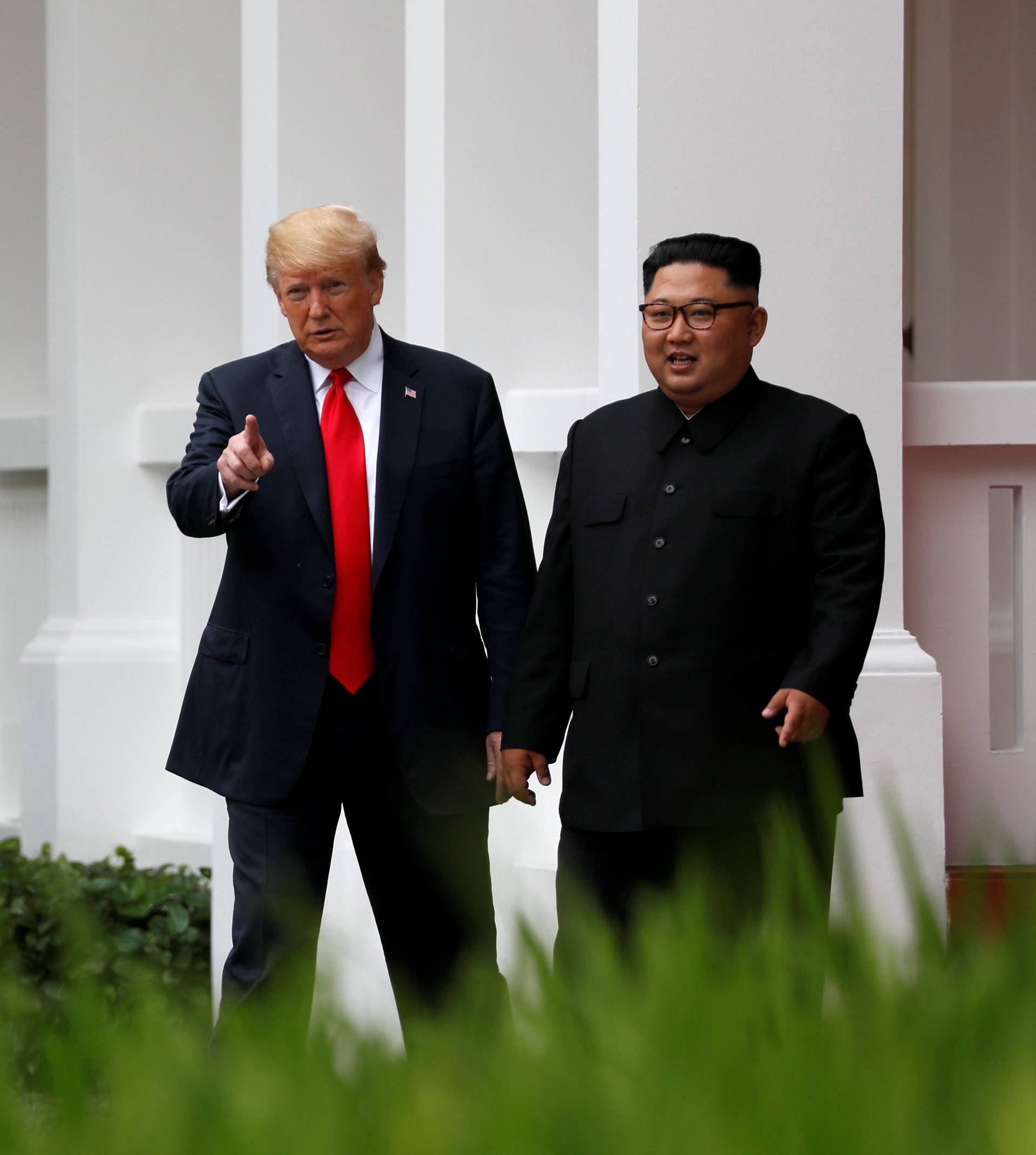 U.S. President Donald Trump and North Korean leader Kim Jong Un walk after lunch at the Capella Hotel on Sentosa island in Singapore