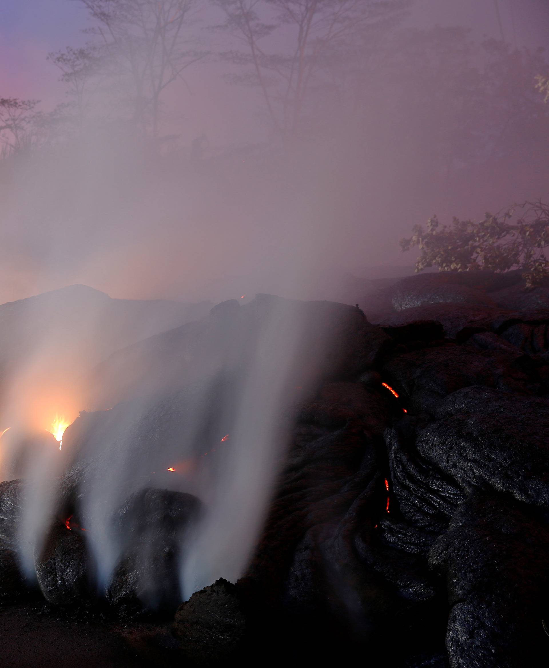 Volcanic gases rise from the Kilauea lava flow that crossed Pohoiki Road near Highway 132, near Pahoa, Hawaii