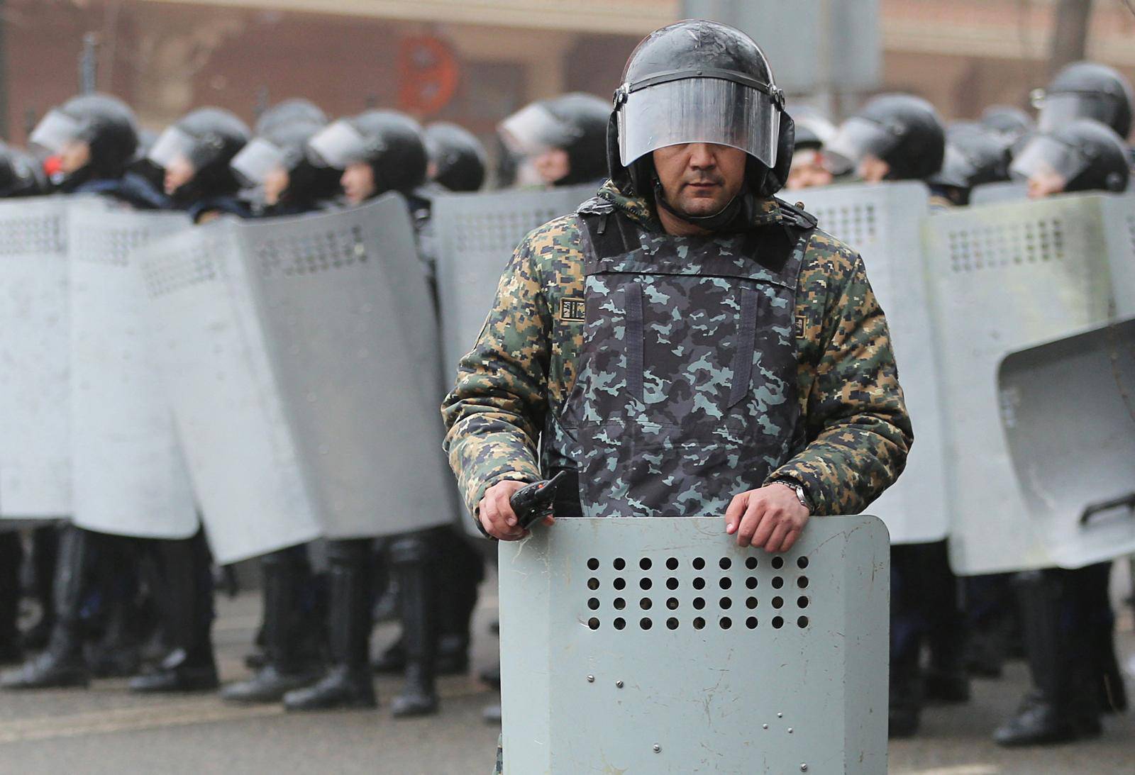 A Kazakh law enforcement officer stands guard during a protest triggered by fuel price increase in Almaty