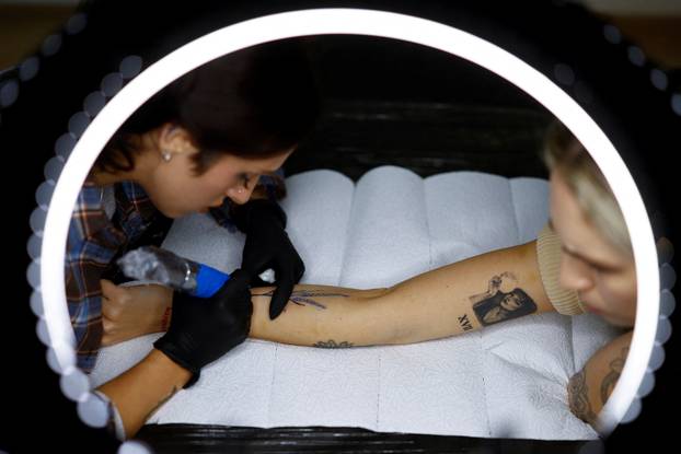Tattoo artist Valeriia Stashenko makes a tattoo of ears of wheat, which symbolise welfare in Ukrainian tradition, in Kyiv