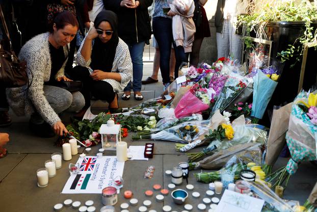 People take part in a vigil for the victims of an attack on concert goers at Manchester Arena, in central Manchester