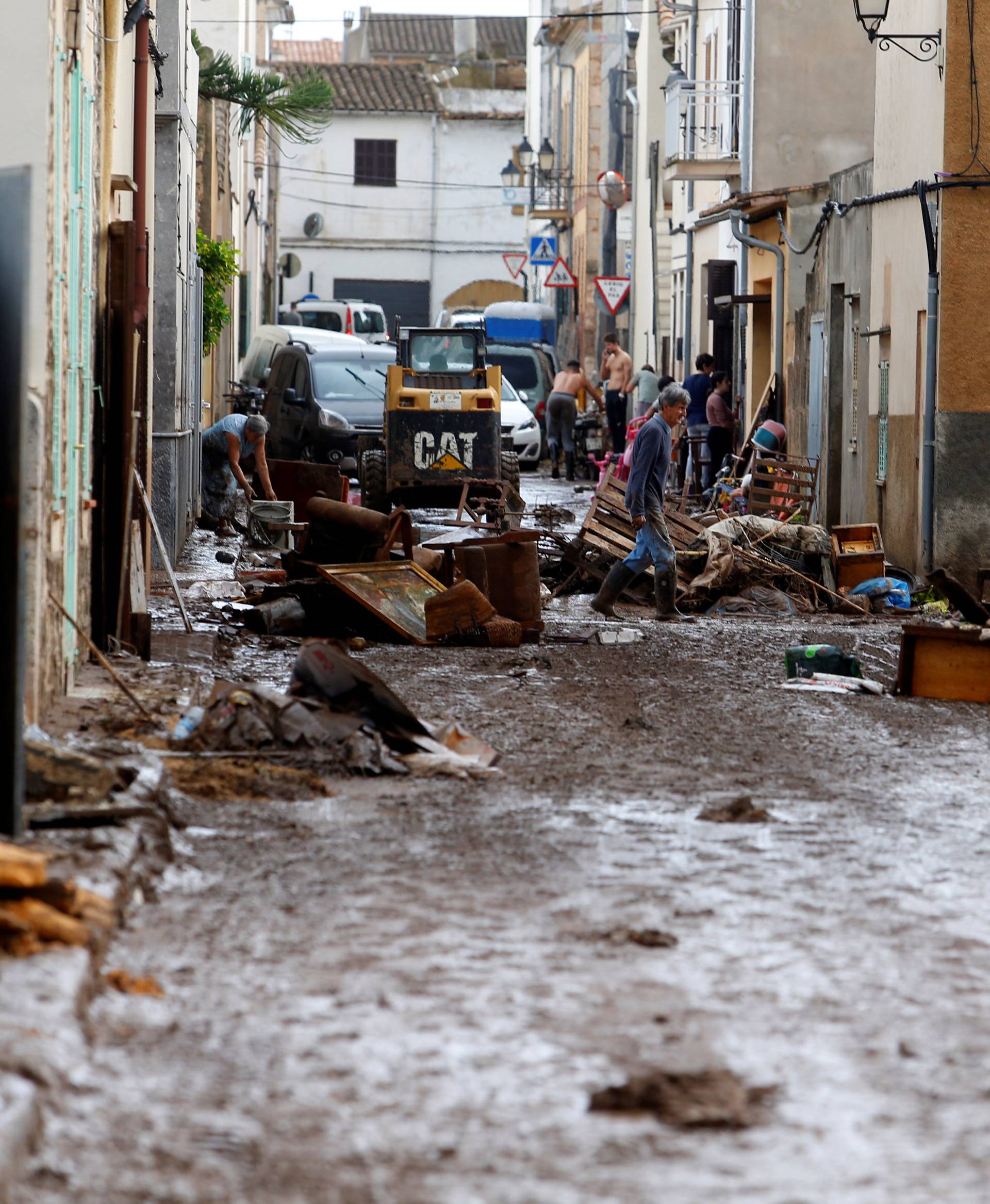 People clear the debris as heavy rain and flash floods hit Sant Llorenc de Cardassar on the island of Mallorca