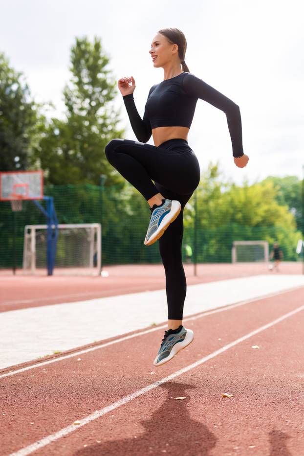 Fitness woman doing cardio interval training outdoors. Female in sportswear exercising outdoors in morning.
