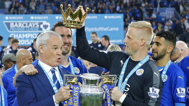 Leicester City manager Claudio Ranieri holds the trophy as he celebrates winning the Barclays Premier League with Kasper Schmeichel and teammates