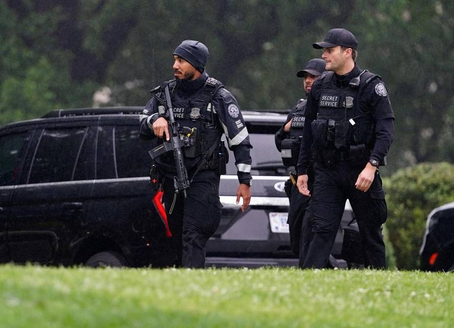 U.S. Secret Service agents walk at the White House after alleged gunshots were heard nearby, in Washington