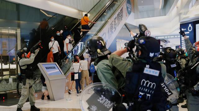 Riot police raise their pepper spray projectile inside a shopping mall as they disperse anti-government protesters during a rally, in Hong Kong