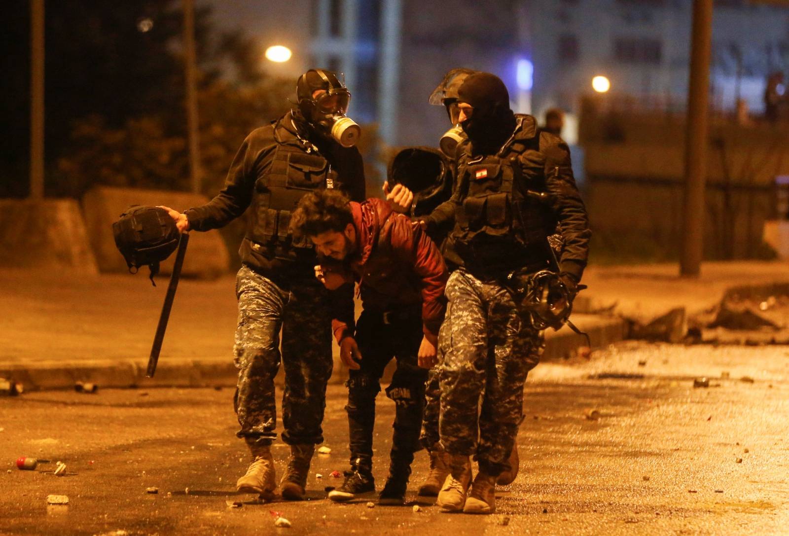 Riot police restrain a protestor during a protest against a ruling elite accused of steering Lebanon towards economic crisis in Beirut