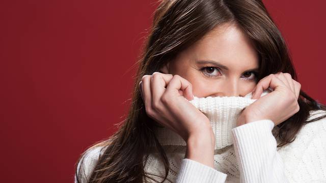 Woman cuddling down into her polo-neck jumper