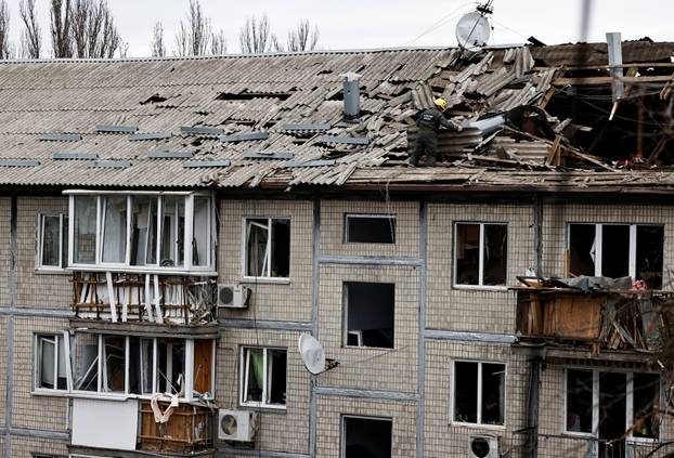 Emergency responders work at the site of a Russian drone strike on an apartment building, in Kyiv