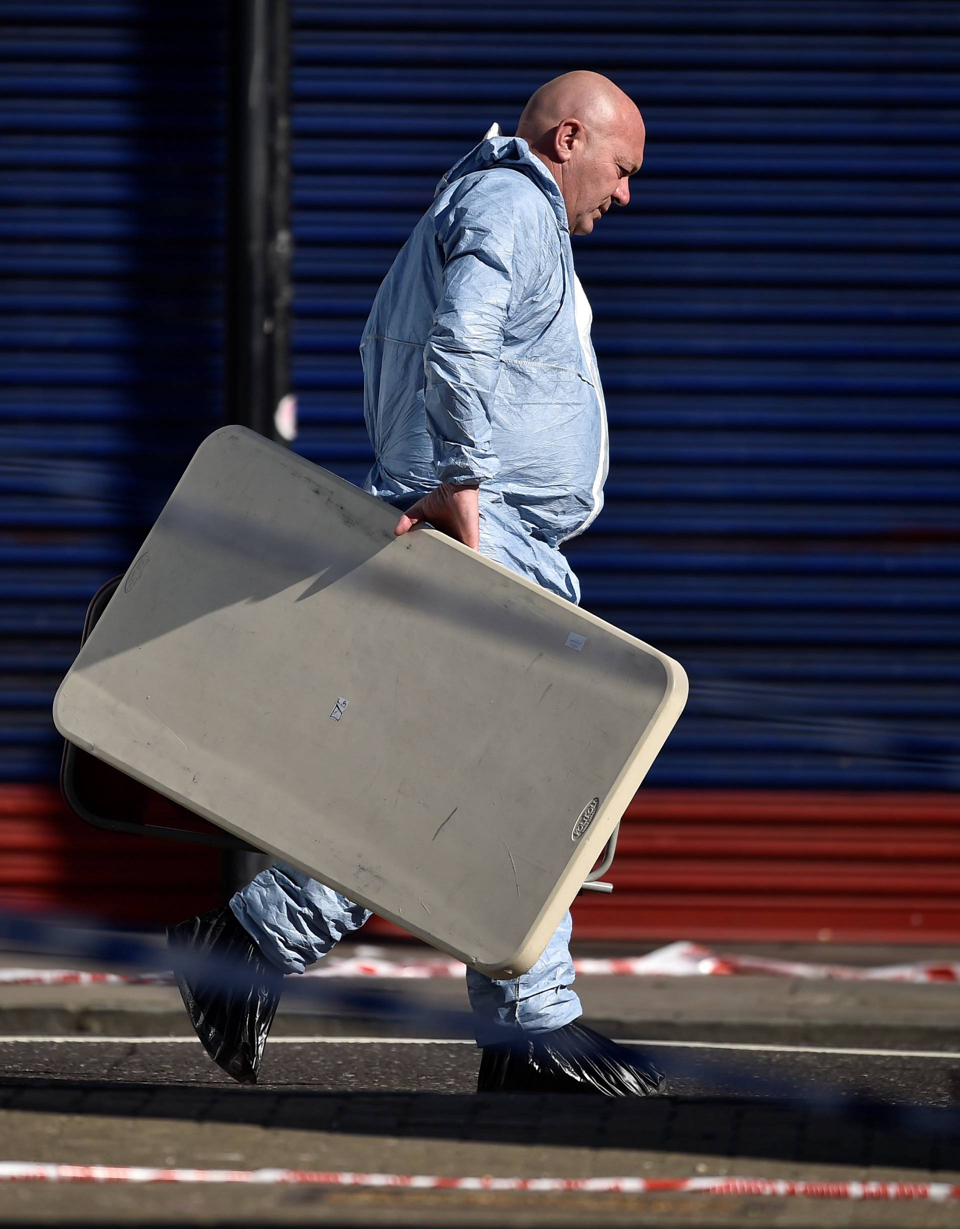 A forensic investigator walks behind cordon tape at the scene of an attack where a man drove a van at muslim worshippers outside a mosque in Finsbury Park in North London