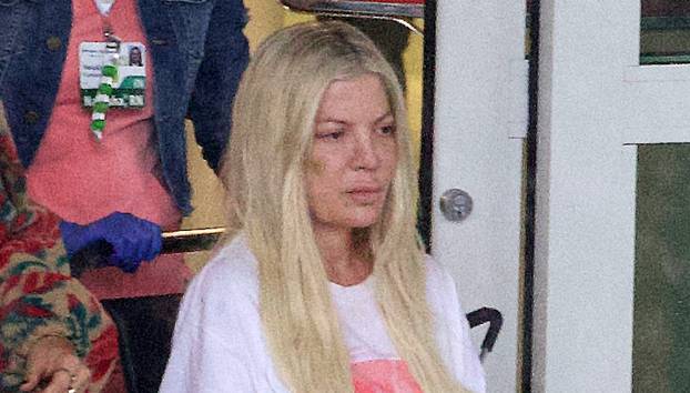 EXCLUSIVE: **PREMIUM EXCLUSIVE RATES APPLY** Bruised And Battered Tori Spelling Leaves The Hospital In A Wheelchair With Visible Marks On Her Face And Arms After Mystery Accident