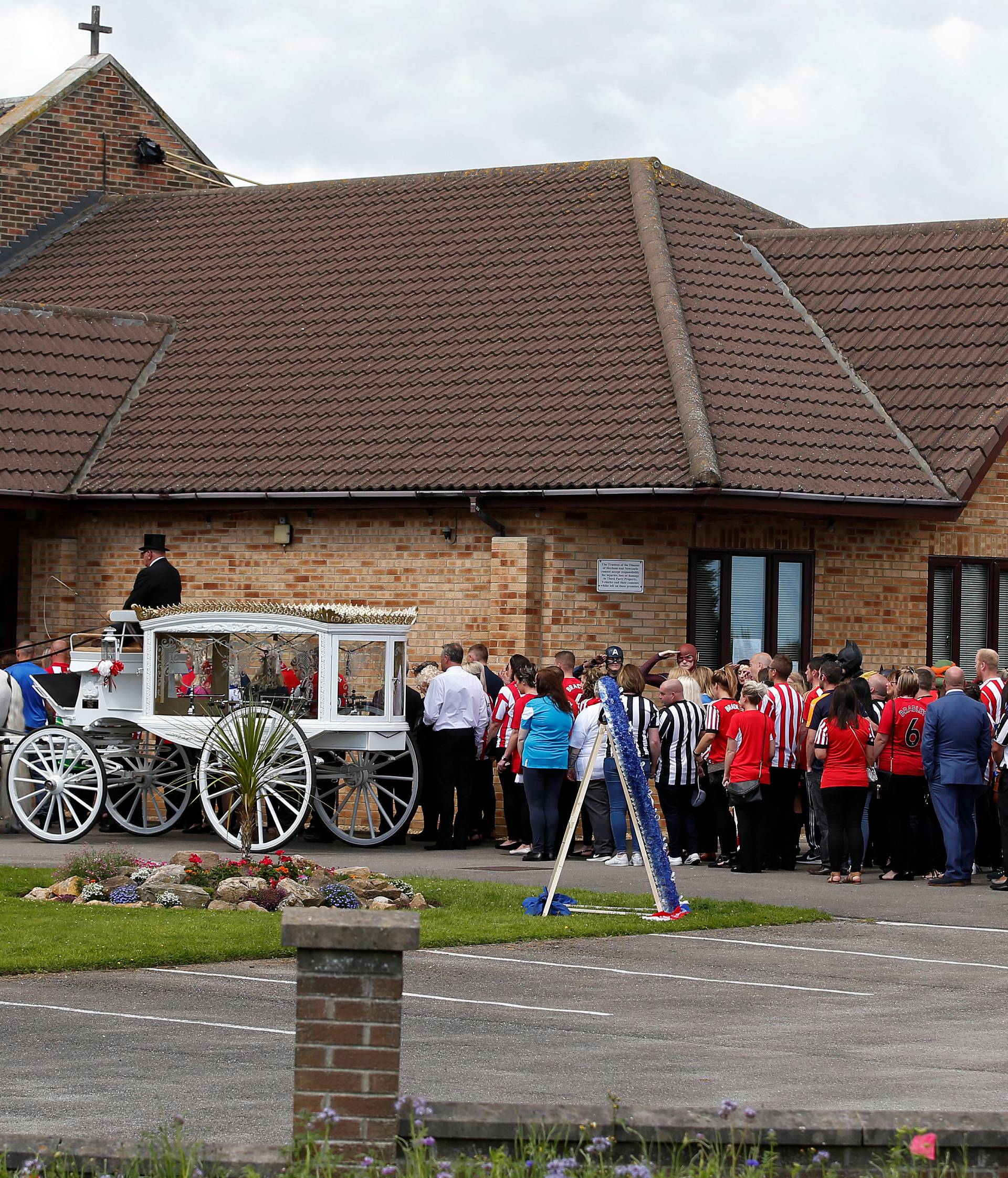Mourner gather outside St Joseph's Church ahead of the funeral of Bradley Lowery