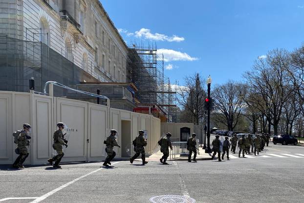 National Guard troops run towards the U.S. Capitol during a security incident in Washington