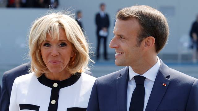 French President Emmanuel Macron and his wife Brigitte Macron leave after the traditional Bastille Day military parade on the Champs-Elysees avenue in Paris