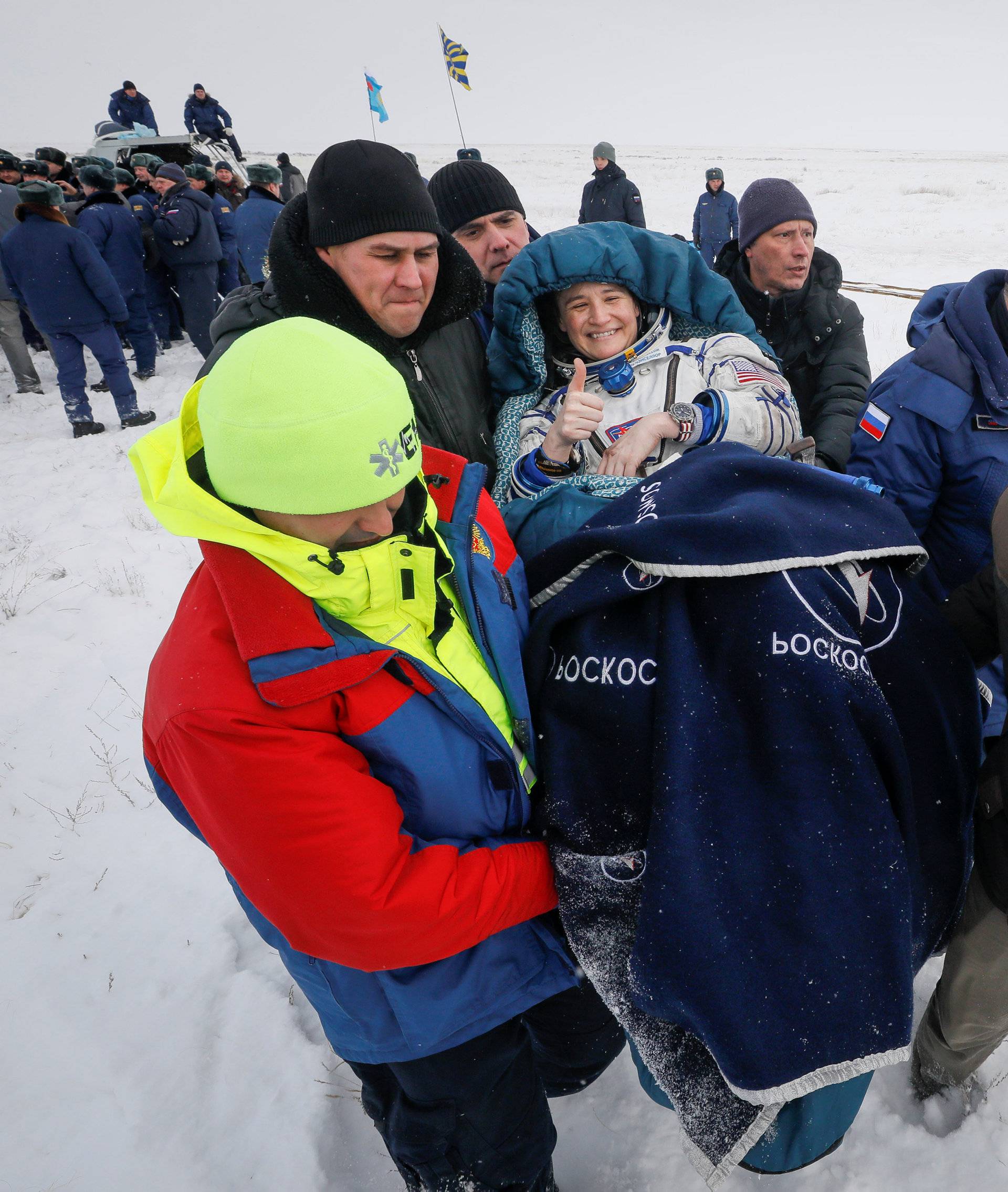 Ground personnel carry International Space Station crew member Aunon-Chancellor after landing near Zhezkazgan