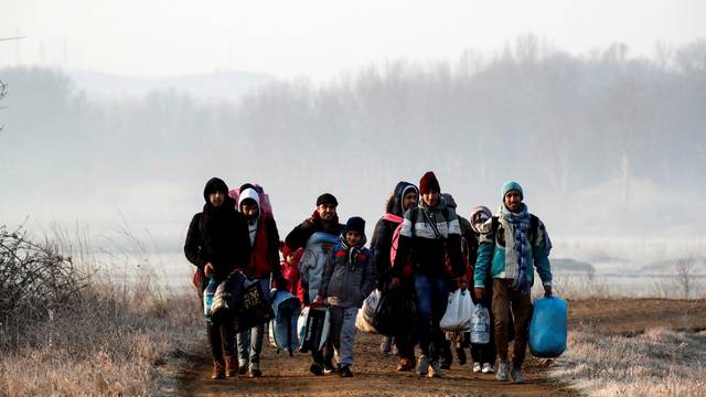 Migrants walk along the Evros river to reach Greece, near the Turkish border city of Edirne