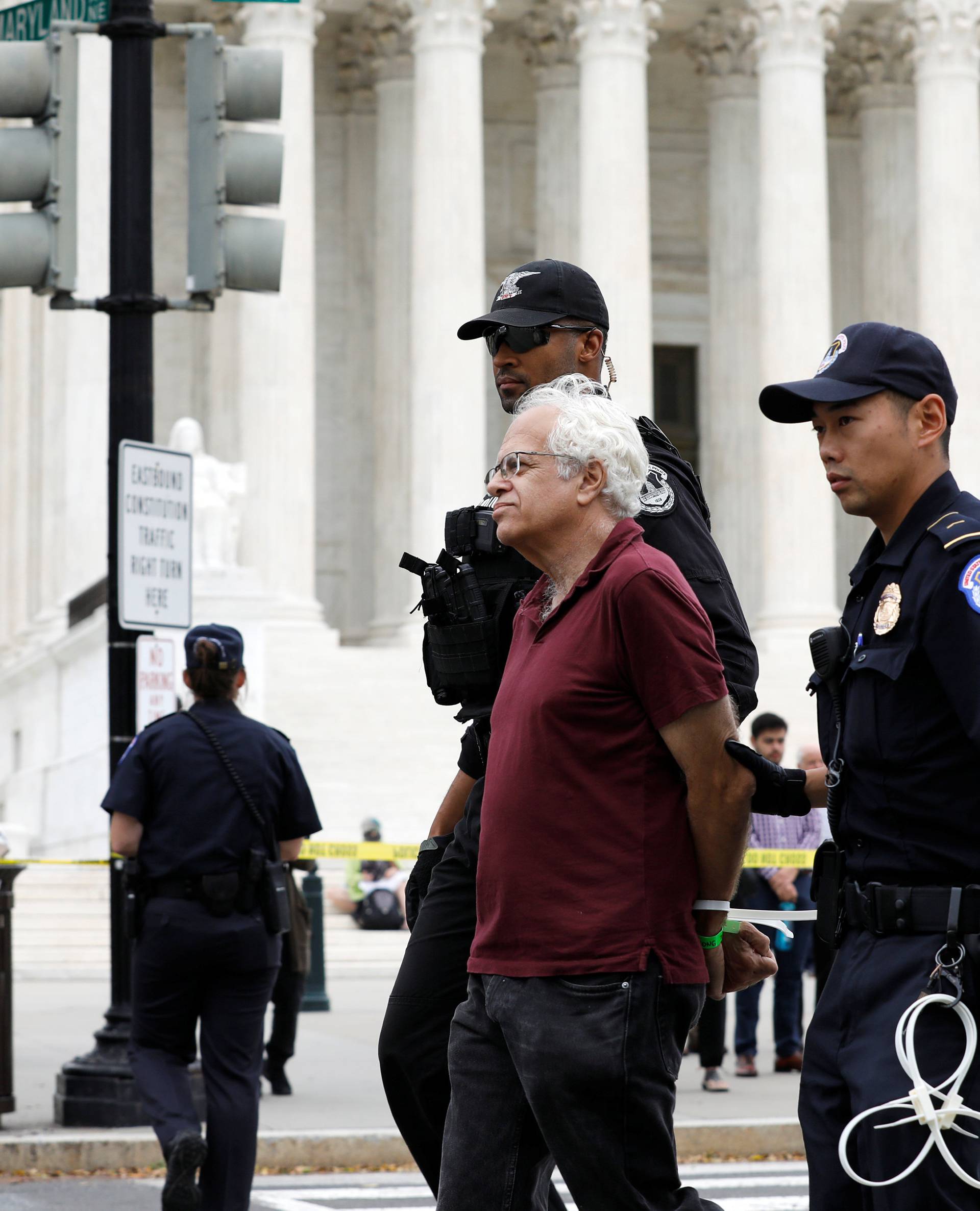 Protestor is arrested for blocking street in front of U.S. Supreme Court while demostrating against confirmation of Supreme Court nominee Kavanaugh on Capitol Hill in Washington