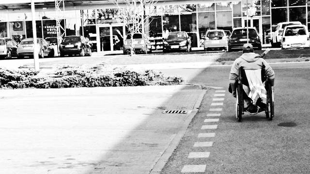 A man using wheel chair on an empty road in Stuttgart - Germany. Black and white image