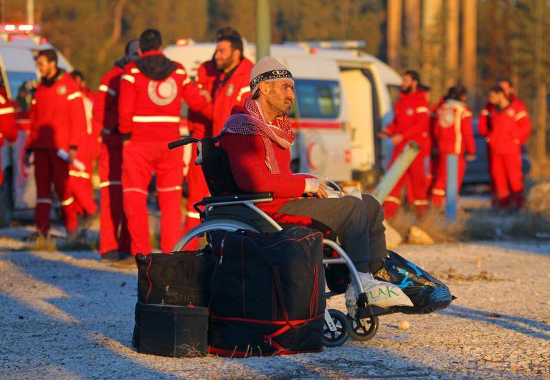 An evacuee from rebel-held east Aleppo, sits on a wheelchair upon his arrival with others to the town of al-Rashideen