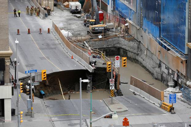 Emergency workers look at a large sinkhole in Ottawa