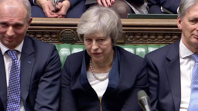 Prime Minister Theresa May sits down in Parliament after the vote on May's Brexit deal, in London