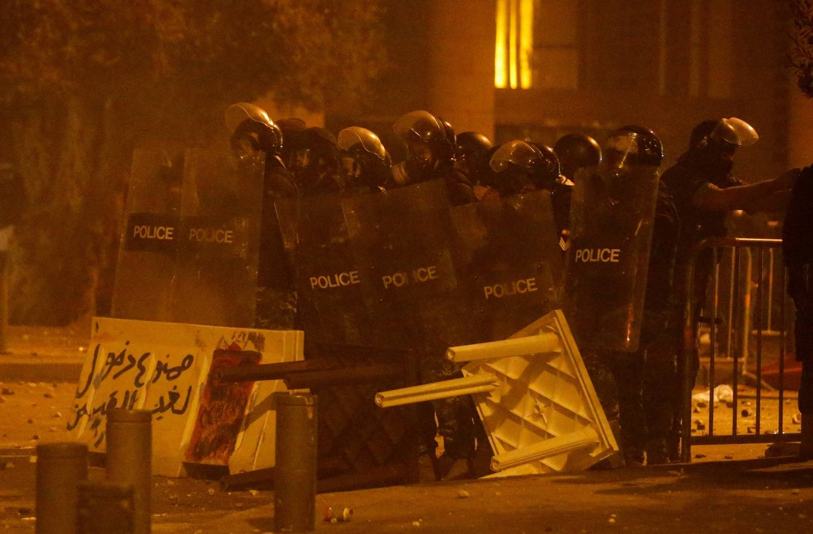 Riot police stand in position behind riot shields during a protest against a ruling elite accused of steering Lebanon towards economic crisis in Beirut