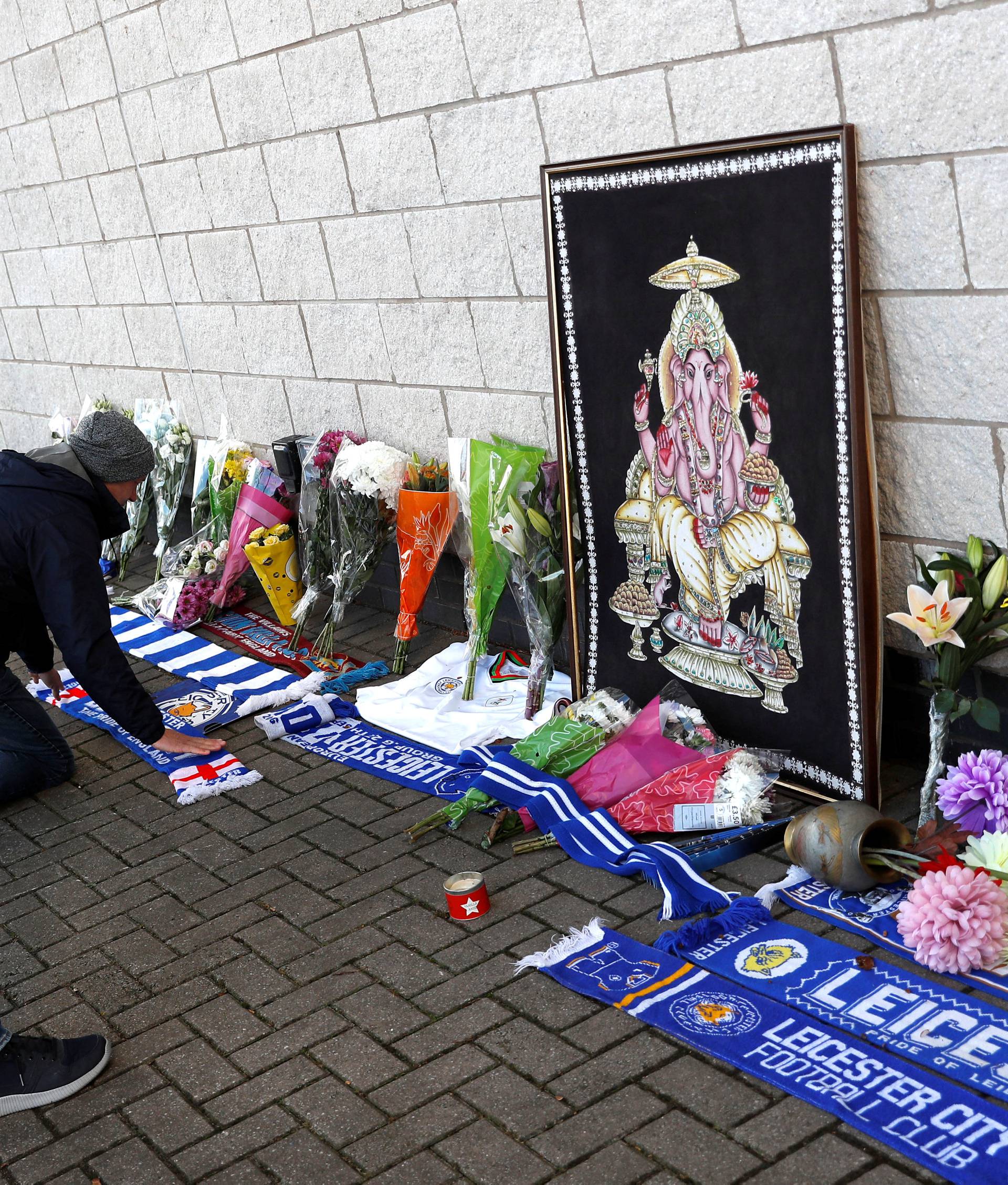 Leicester City football fans place flowers outside the football stadium after the helicopter of the club owner Thai businessman Vichai Srivaddhanaprabha crashed when leaving the ground on Saturday evening after the match, in Leicester