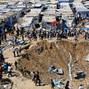 FILE PHOTO: Palestinians inspect the site of an overnight Israeli strike on a medicine warehouse, in Deir al-Balah