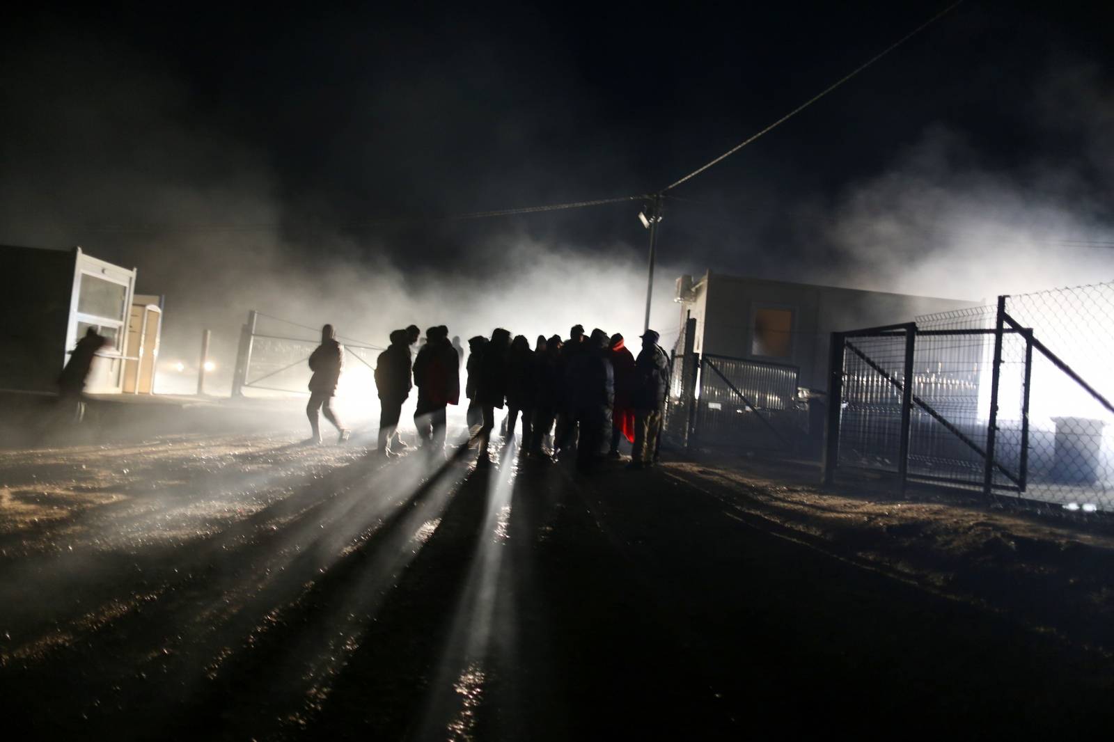 People stand at camp "Lipa" after it was closed, in Bihac