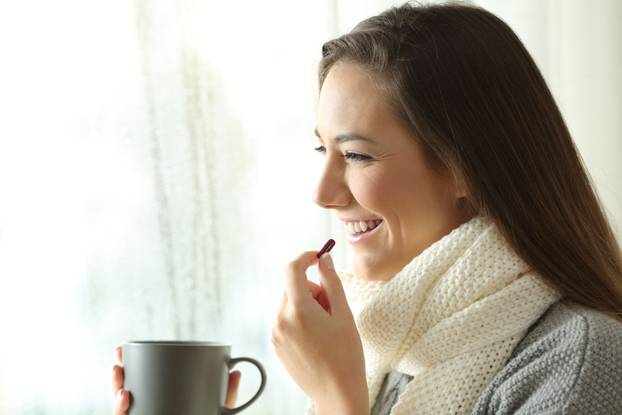 Side,View,Portrait,Of,A,Happy,Woman,Taking,A,Pill