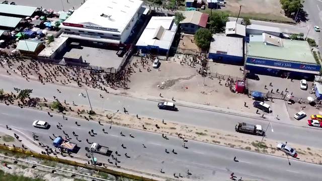 People gather near a building, amid reports of widespread looting and arson as police and the public sector protest over a pay cut that officials blamed on an administrative glitch, in Port Moresby