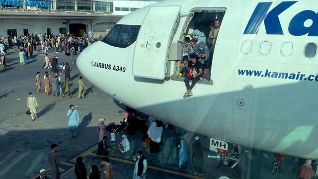 People at the door of an aircraft at the airport in Kabul