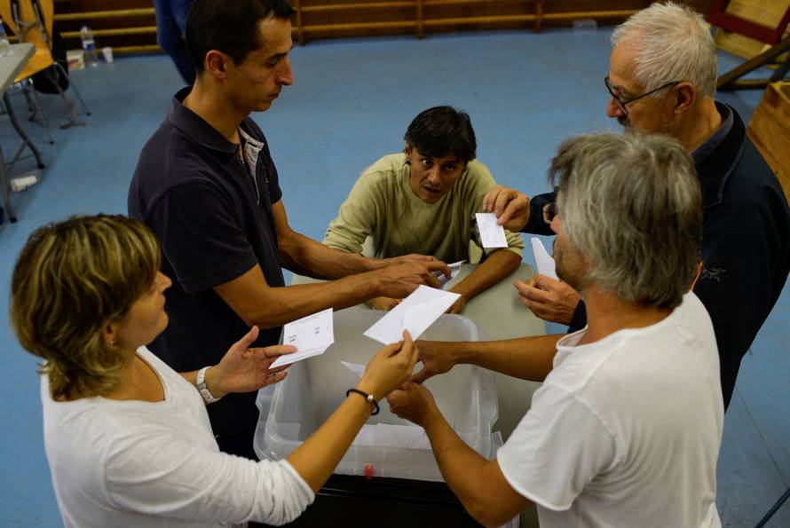 Poll workers count ballots after polls closed in the banned independence referendum in Vic