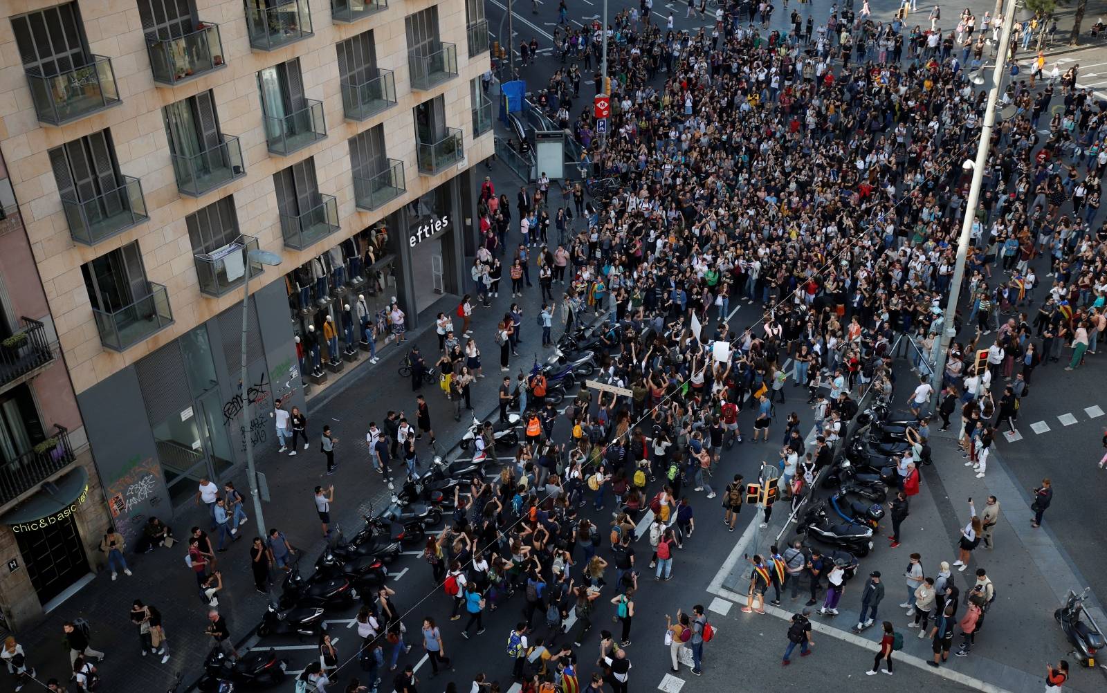 Students sit at Plaza Universidad after a verdict in a trial over a banned independence referendum, in Barcelona