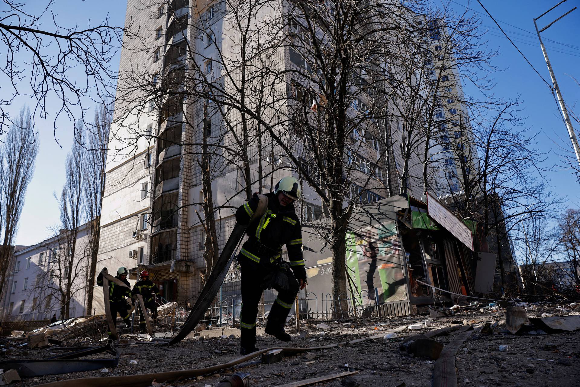 Rescuers work next to an apartment building that was hit by shelling in Kyiv