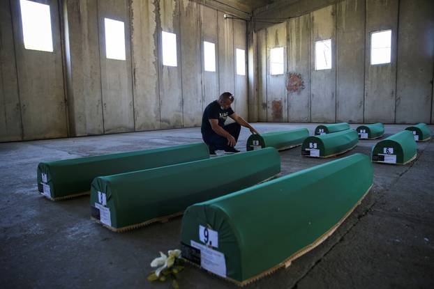 Bahrudin Salkovic, who lost his father, reacts next to the coffins with remains of newly identified victims at Potocari-Srebrenica Memorial ahead of burial on July 11, in Potocari