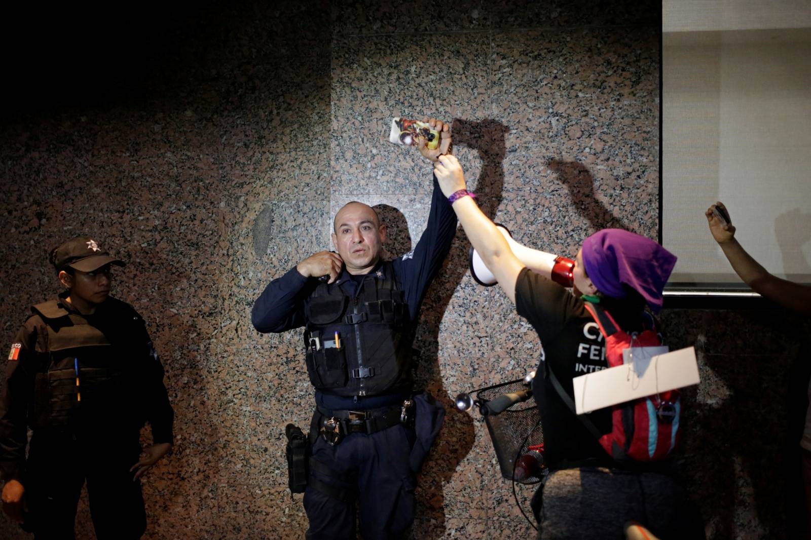 A policeman records with his cell phone during the "They Don't Protect Me, They Rape Me" demonstration in Monterrey