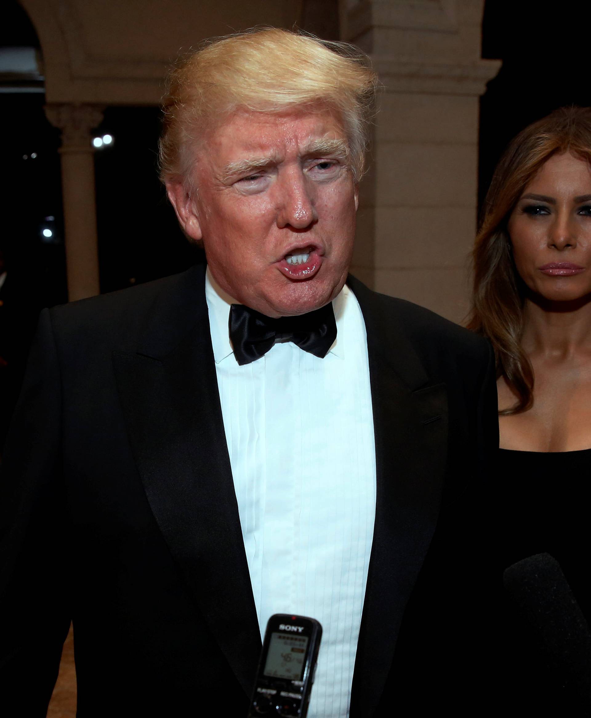 U.S. President-elect Donald Trump talks to reporters as he and his wife Melania Trump arrive for a New Year's Eve celebration with members and guests at the Mar-a-lago Club in Palm Beach