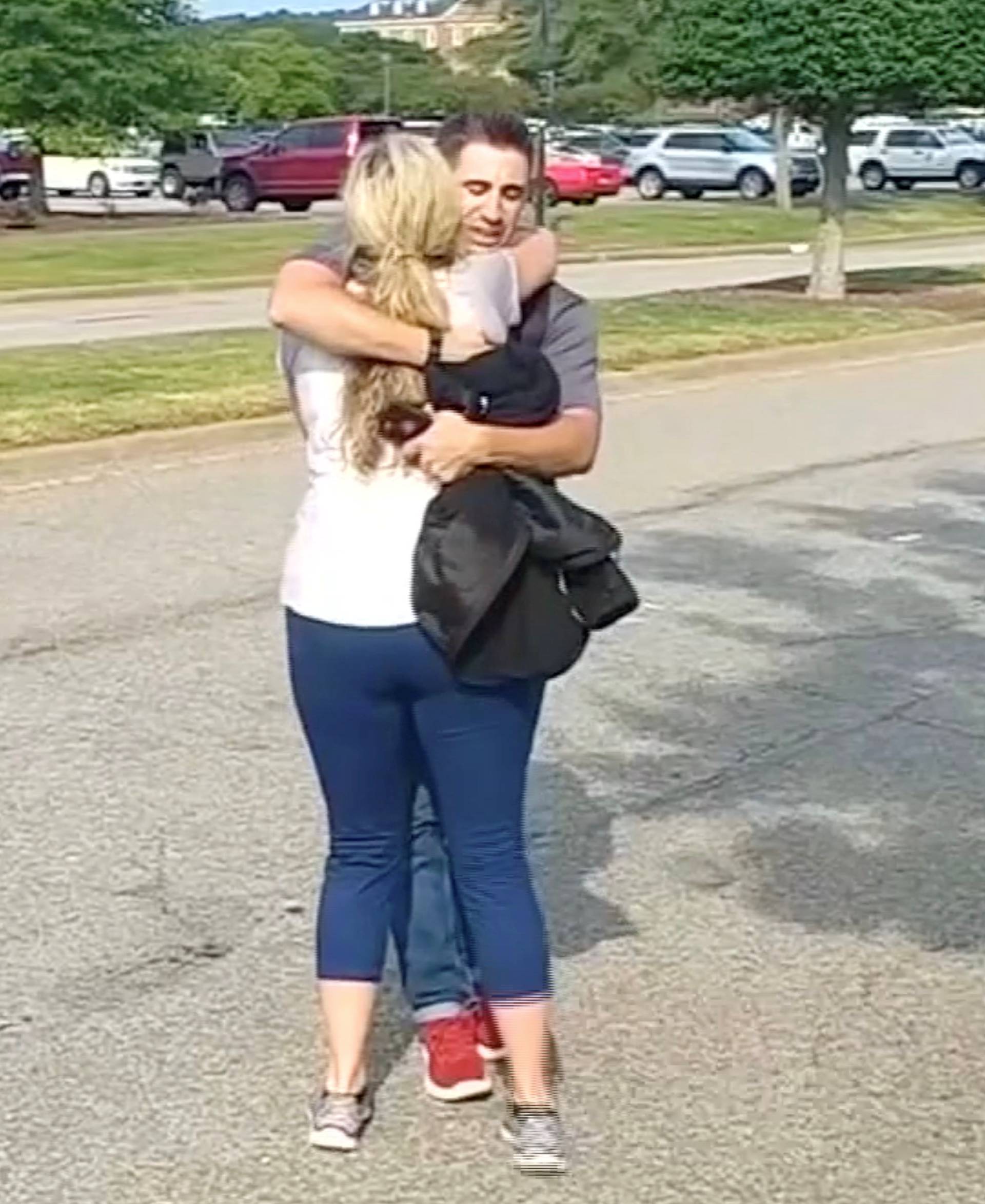 People embrace after being evacuated from a building by police in this still image taken from video following a shooting incident at the municipal center in Virginia Beach