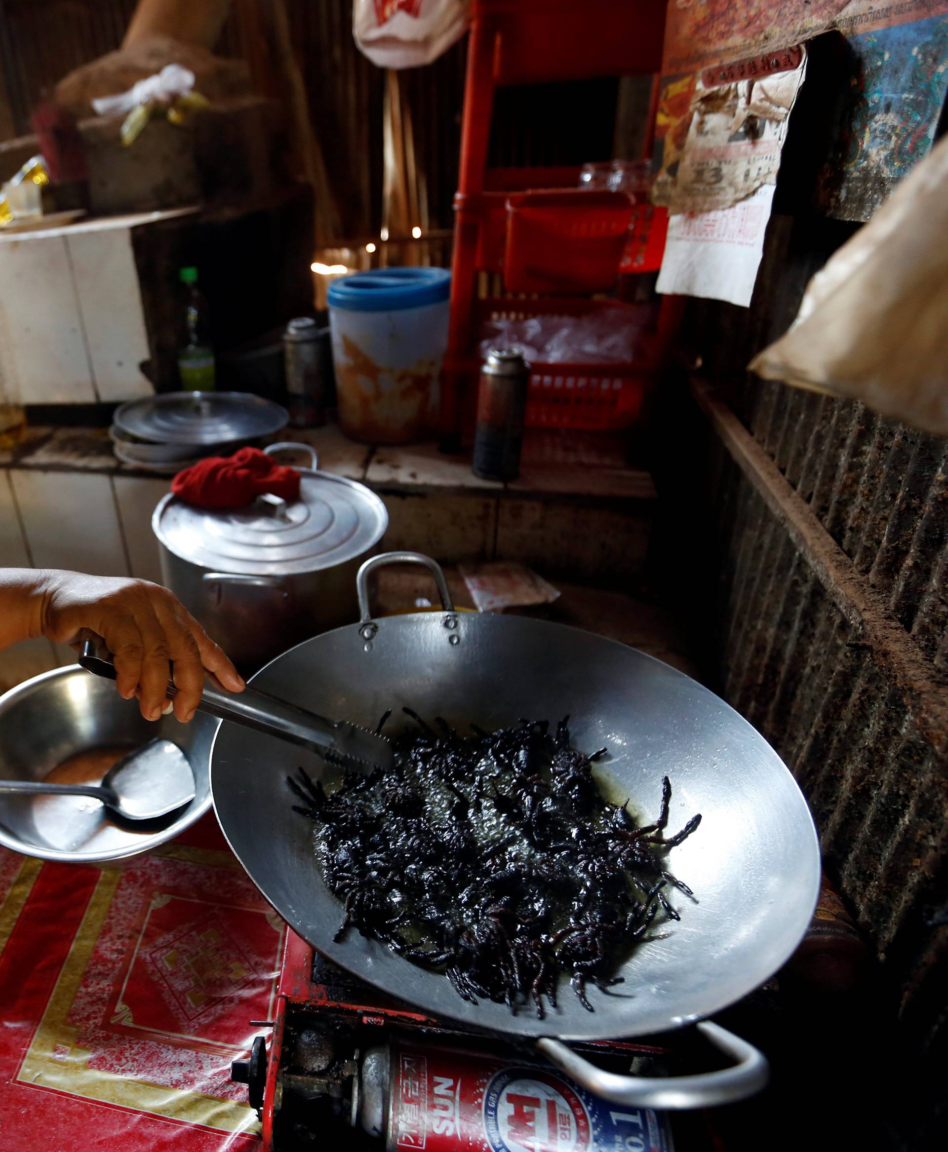 A woman fries tarantulas at her home in Kampong Cham province in Cambodia