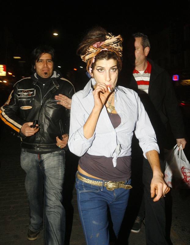 Amy Winehouse has a cigarette as she picks up some KFC with her bodyguard in Camden Town