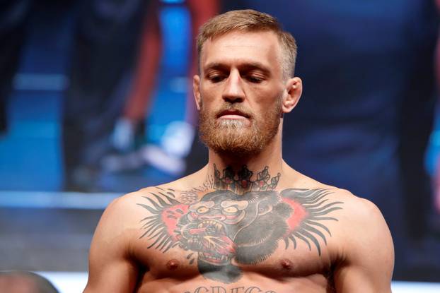 UFC lightweight champion Conor McGregor of Ireland stands on the scale during his official weigh-in at T-Mobile Arena in Las Vegas