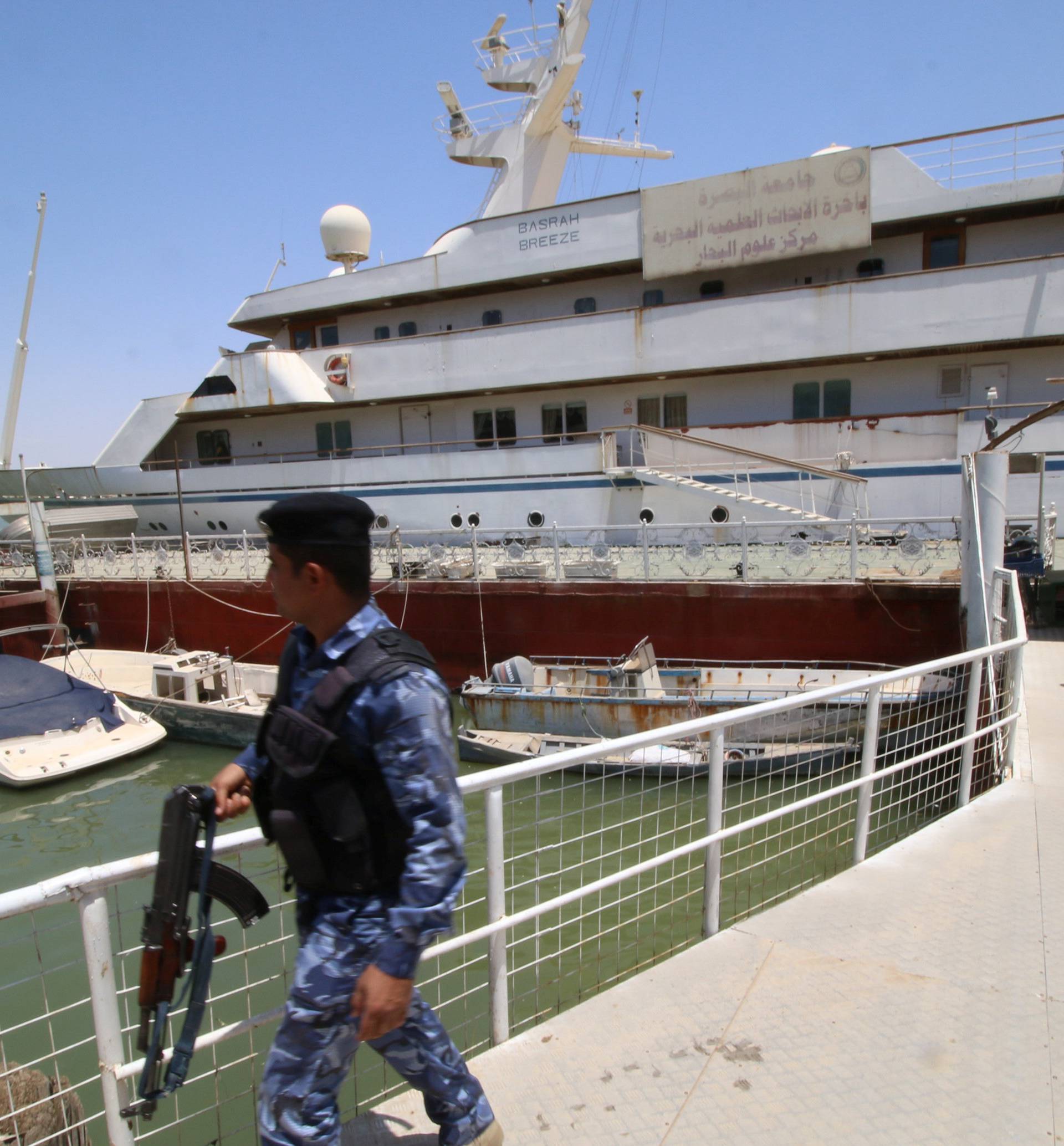 An Iraqi policeman walks past the yacht called "Basrah Breeze", once owned by former Iraqi president Saddam Hussein, who was toppled in a U.S.-led invasion in 2003, in the southern port of Basra