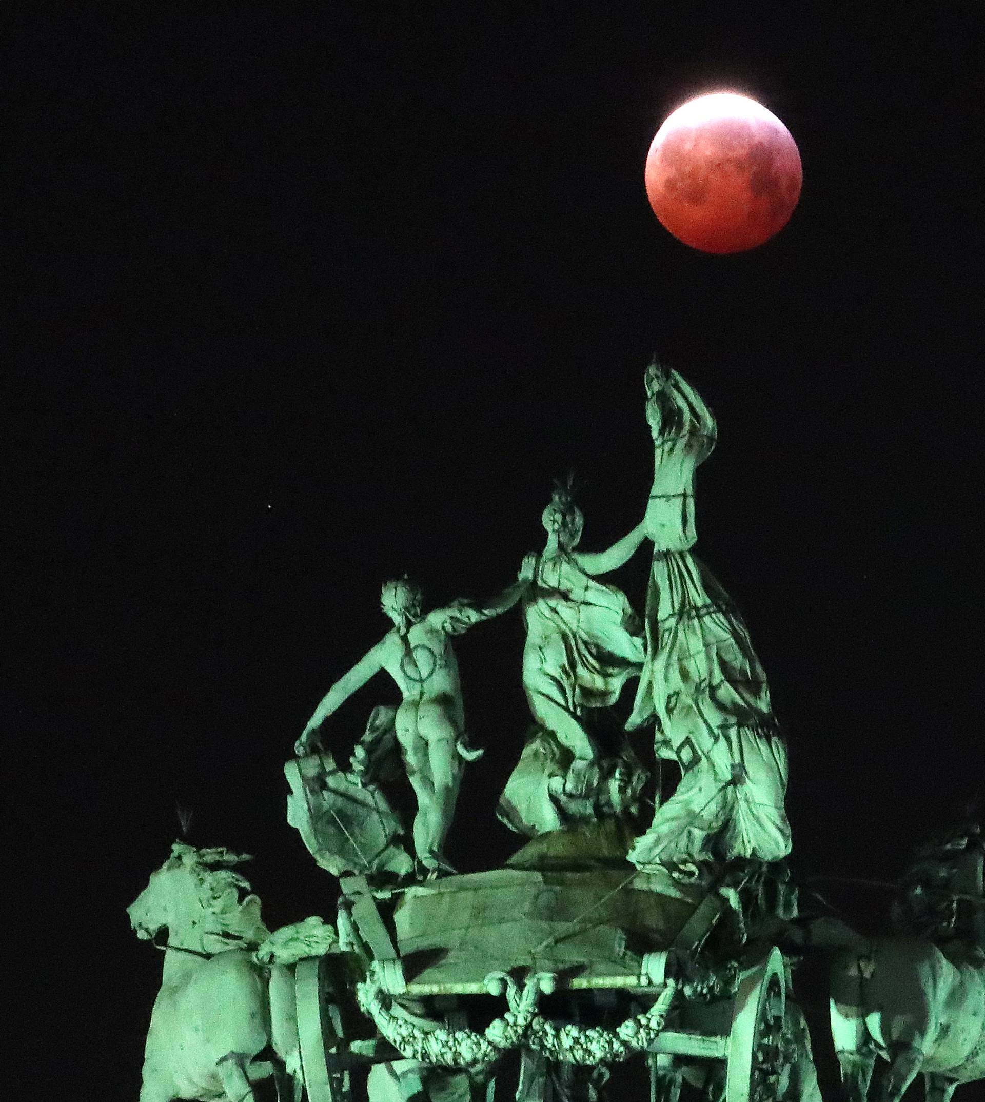 The moon is seen beside a quadriga on the top of the Cinquantenaire arch during a total lunar eclipse known as the "Super Blood Wolf Moon", in Brussels