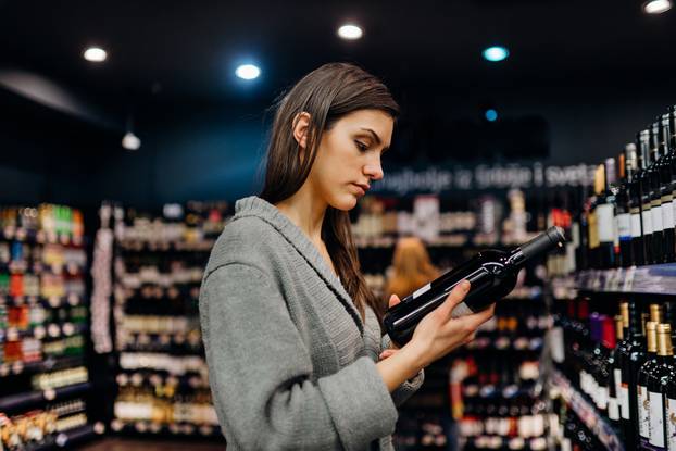 Woman,Shopping,For,Expensive,Wine,In,Supermarket,Alcohol,Store.choosing,And