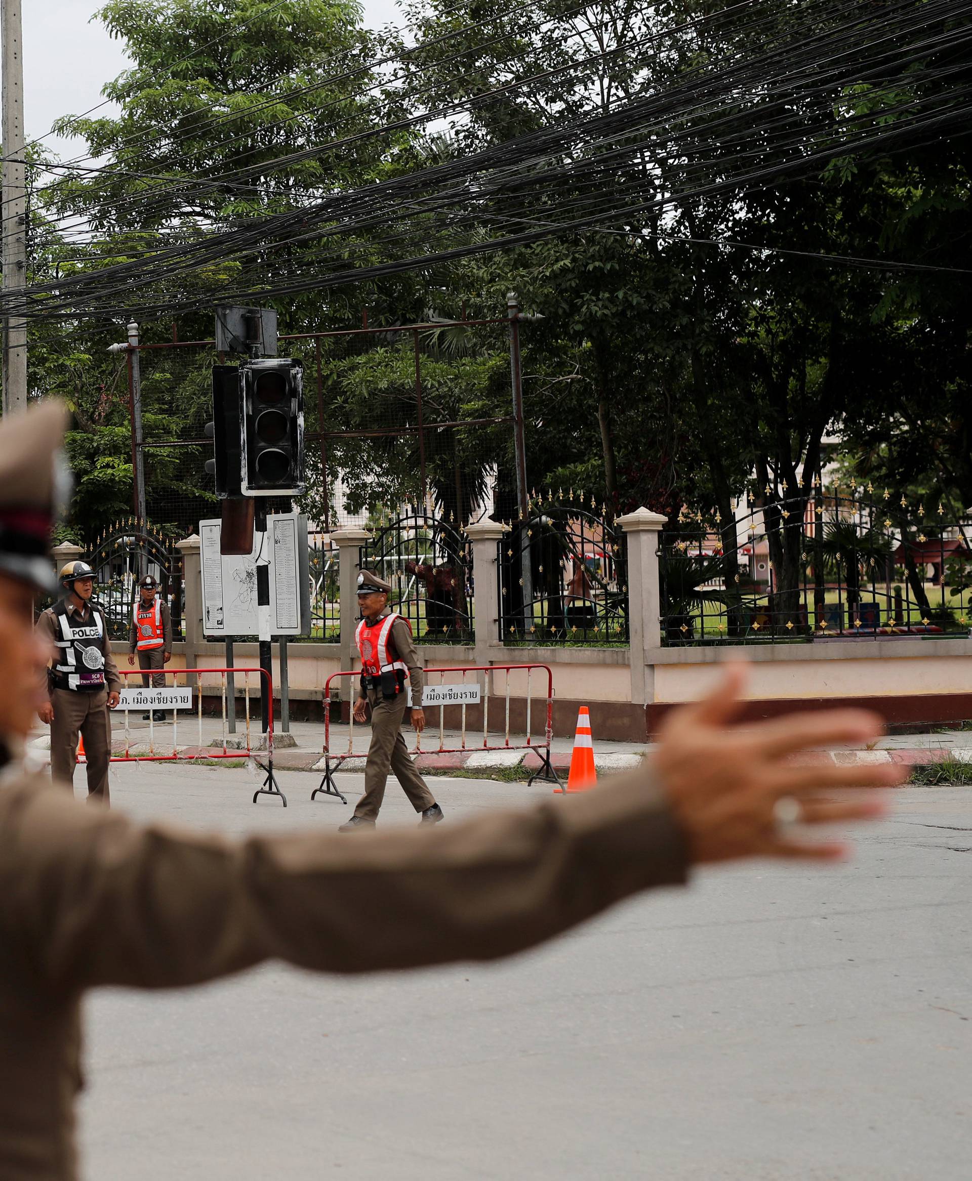Police block a road leading to a hospital near a military airport in Chiang Rai
